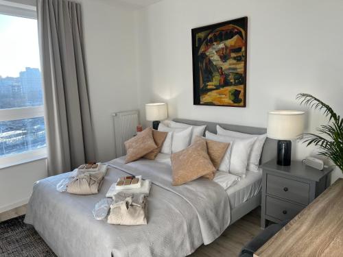ein Schlafzimmer mit einem weißen Bett mit Kissen und einem Fenster in der Unterkunft Modern Vero Apartments Górskiego in Gdynia