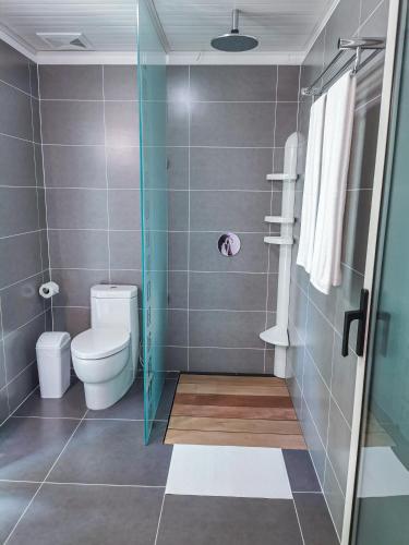a bathroom with a toilet and a glass shower at Blue Joys MSR in Siquijor