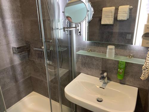 a bathroom with a shower and a sink and a mirror at Ziegenbruch´s Gastronomie in Spenge