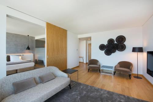 a living room with a couch and a bed at Iberostar Selection Lisboa in Lisbon