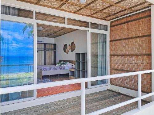 a balcony of a house with a view of the ocean at Blue Joys MSR in Siquijor