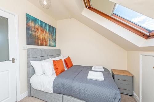a bedroom with a bed with orange pillows and a window at Bridge End Mill by Guestz in Settle