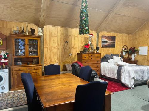 a bedroom with a bed and a dining room table at Waiora la grange cottage in Otaki