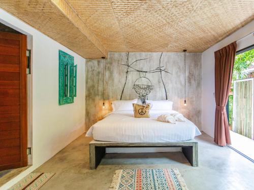 a bedroom with a white bed and a table at Dreamcatcher Boutique Hotel in Bophut 