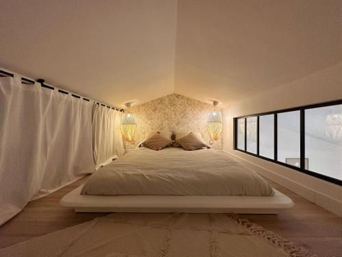 ein Schlafzimmer mit einem großen weißen Bett mit zwei Lampen in der Unterkunft Le Petit Bohème - Cocon Rochelais in La Rochelle