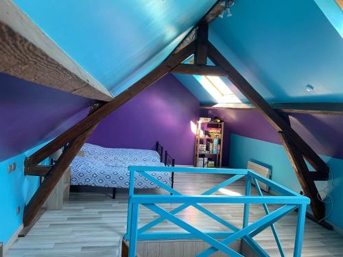 um quarto com uma cama e um tecto azul em « Le temps d’un instant » dépendance em Solre-le-Château