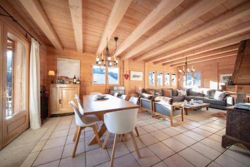 un salon avec un plafond en bois et une table et des chaises dans l'établissement Chalet Renard in Morzine, à Montriond