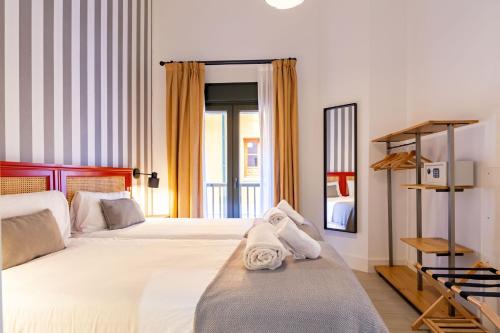 ein Schlafzimmer mit einem Bett und Handtüchern auf einer Bank in der Unterkunft Ohliving Cathedral in Sevilla