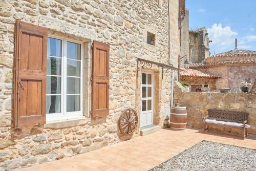 a stone building with a bench and a window at Domaine du Prieuré Couvent & Presbytère in Carcassonne