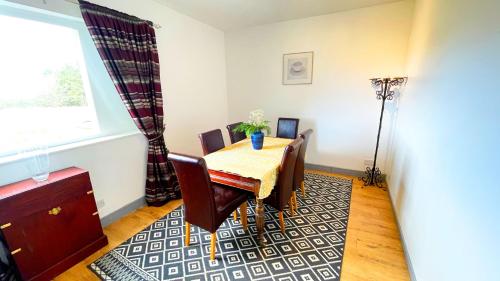a dining room with a table and chairs and a window at Pentland Farm Cottage Annex in Kirknewton