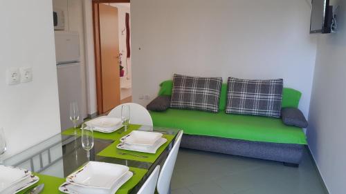 Jurdani的住宿－Apartments Carmen，客厅配有带桌子的绿色沙发