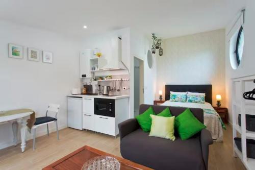 uma sala de estar com uma cama e um sofá e uma cozinha em Urban Cabin em Vila Nova de Gaia