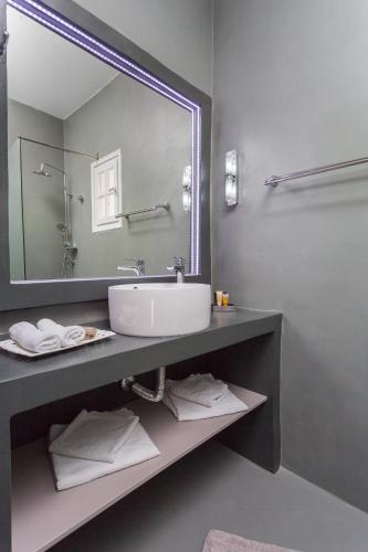 a bathroom with a sink and a large mirror at Zoumis Residence in Naousa