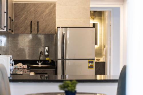 a kitchen with a stainless steel refrigerator and cabinets at El Gouna Elite Worldwide Sea & Garden Residences - Hurghada, Egypt in Hurghada