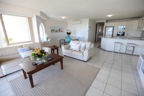a living room with a couch and a table at Osprey Apartments in Mooloolaba