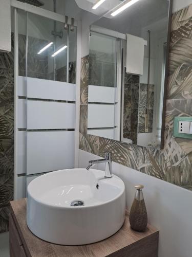 een badkamer met een witte wastafel en een spiegel bij Sole&Scudo in Venaria Reale