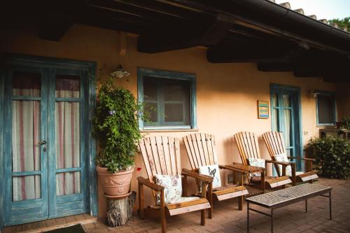 a group of chairs and a potted plant in front of a house at Il Poggio di Teo in Manciano