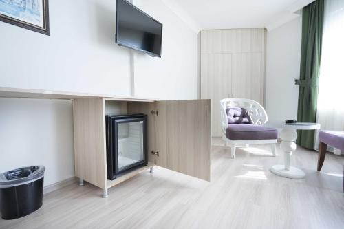 a living room with a tv and a chair at Hotel Libiza in Gebze
