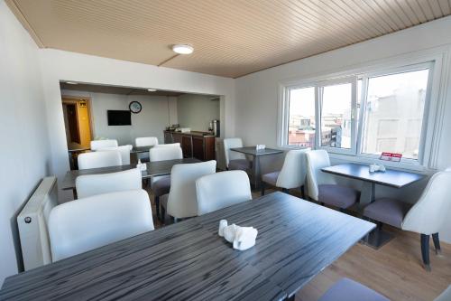 a dining room with tables and white chairs at Hotel Libiza in Gebze