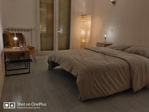 una camera con un grande letto e un tavolo di Grand appartement avec terrasse, Paris12 a Parigi