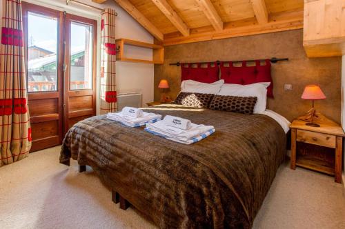 1 dormitorio con 1 cama grande y toallas. en Chalet le Tremplin, en Chamonix-Mont-Blanc