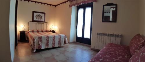 a bedroom with a bed and a window and a couch at La Casa del Regidor in Fermoselle