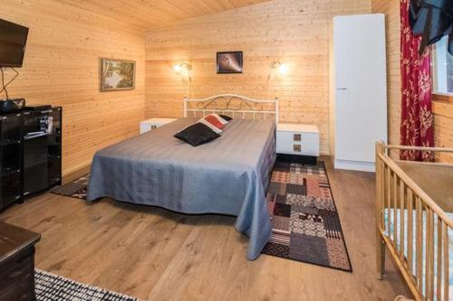 a bedroom with a bed in a wooden room at Mäntymäki in Kelkala