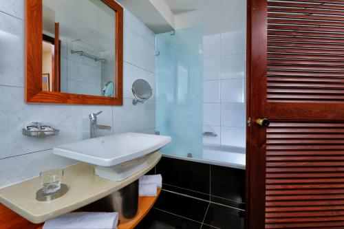 a bathroom with a sink and a mirror and a tub at Vasia Resort & Spa in Sisi
