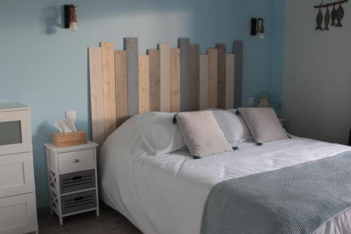 a bed with a wooden headboard in a bedroom at Le Manoir de KEROFIL 