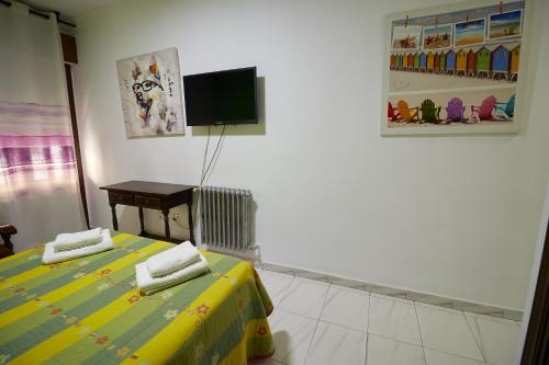 a bedroom with two beds and a tv on the wall at Hotel Virgen de los Reyes in Ronda