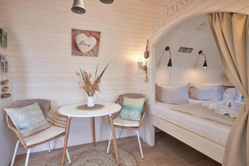 Habitación con cama, mesa y sillas. en schwimmendes Iglu Romantik & Family en Parey