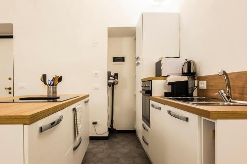 a kitchen with white cabinets and a sink at Affittacamere Archivolto del Teatro in Albenga