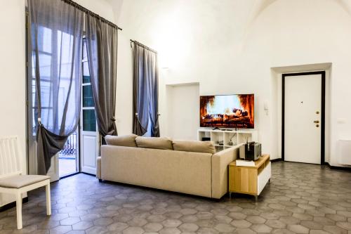 uma sala de estar com um sofá e uma televisão em Archivolto del Teatro em Albenga