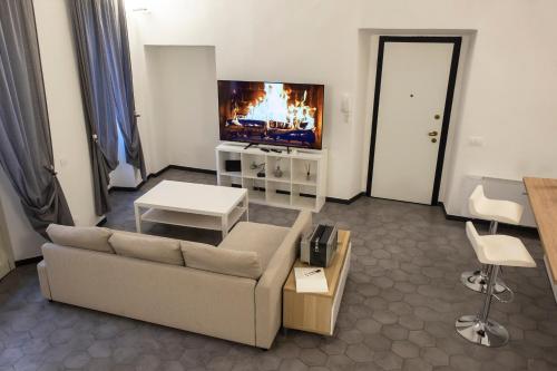 a living room with a couch and a flat screen tv at Affittacamere Archivolto del Teatro in Albenga