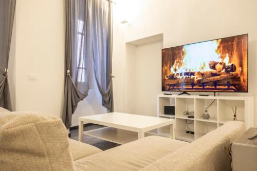 a living room with a couch and a tv at Affittacamere Archivolto del Teatro in Albenga