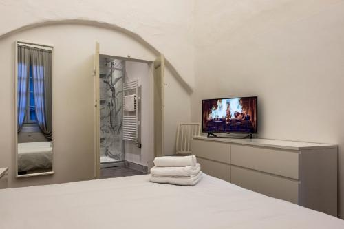 sypialnia z łóżkiem z telewizorem w obiekcie Affittacamere Archivolto del Teatro w Albendze