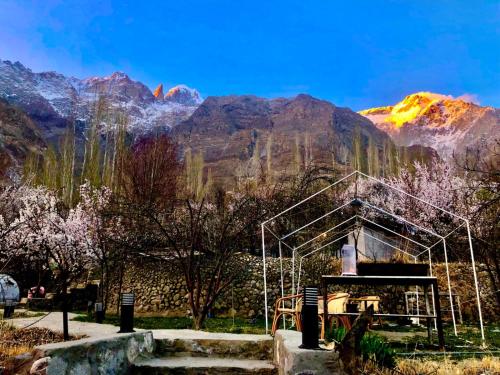 a greenhouse with mountains in the background at Grapes Garden Resort Hunza in Hunza