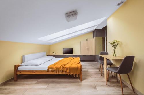 a bedroom with a bed and a table and chairs at Native Apartments Rakowicka 6 in Krakow