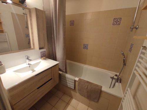 ein Badezimmer mit einem Waschbecken und einer Badewanne in der Unterkunft Résidence les chênes blancs Appartement T2 in Gréoux-les-Bains