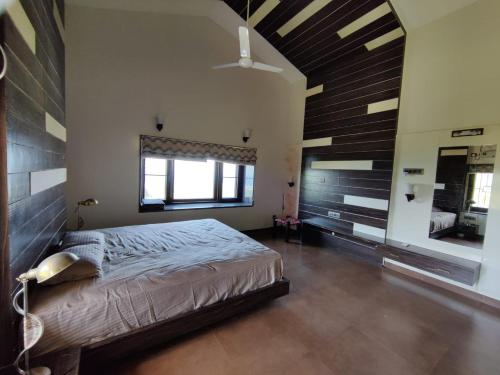 a bedroom with a large bed and a ceiling at Sea Nest Villa, 3BHK Panoramic Sea View , Ganpatipule in Ratnagiri