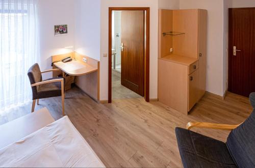 a small room with a desk and a room with a door at Hotel Phönix in Rastatt