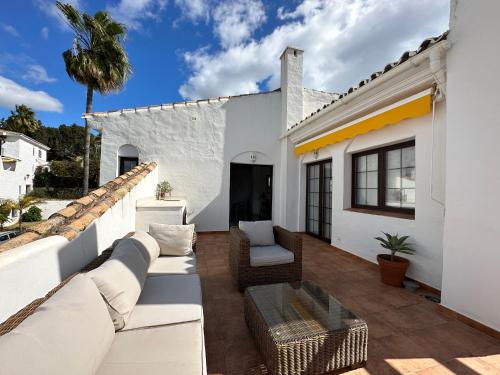 a patio with white furniture and a white house at Aldea Blanca Cozy Penthouse in Puerto Banús in Marbella