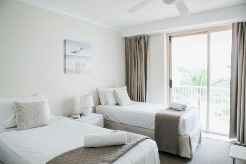 a hotel room with two beds and a window at Osprey Apartments in Mooloolaba