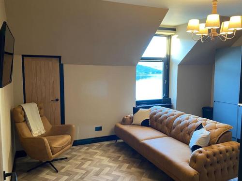 ein Wohnzimmer mit einem Sofa und einem Stuhl in der Unterkunft AK Lochview Apartment in Fort William