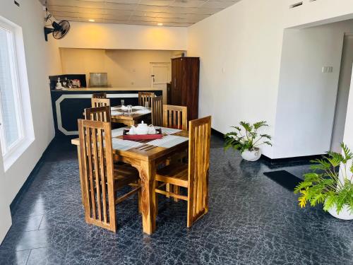 a dining room with a wooden table and chairs at The Lake Round Guest House in Kandy