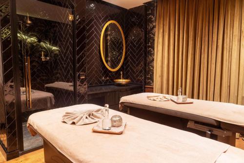 a treatment room with two beds and a mirror at Ramada Plaza By Wyndham Istanbul City Center in Istanbul