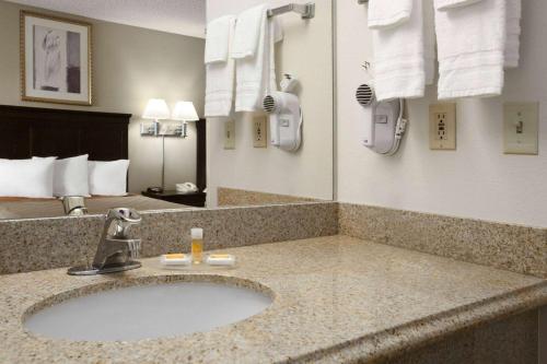 a bathroom with a sink in a hotel room at Days Inn & Suites by Wyndham Rancho Cordova in Rancho Cordova