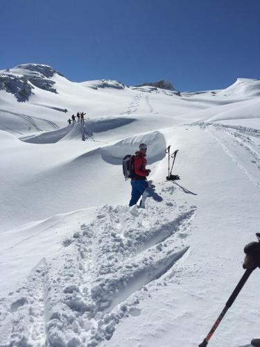 a person with a backpack walking up a snow covered slope at Bergesgrün in Oberstdorf
