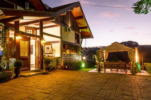 a house with a patio at night at Casablanca Hotel Boutique in Campos do Jordão