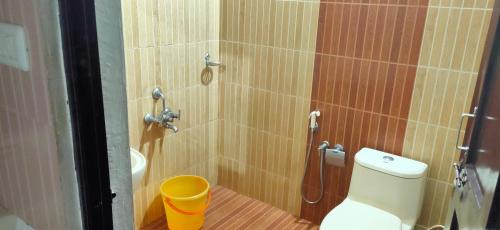a bathroom with a shower with a toilet and a bucket at Kuttickattil Pool Home Stay Kumarakom in Kumarakom